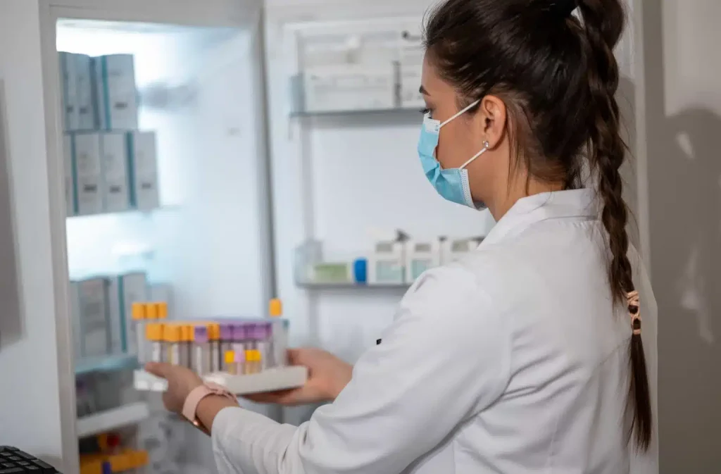 lady taking medical sample from fridge